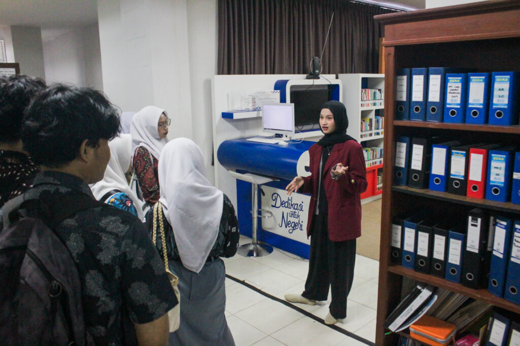 Mahasiswa yang berperan sebagai tour guide menjelaskan perpustakaan Tri Bhakti